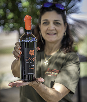 A Doffo Barrel Club member holding a bottle of her Barrel Club wine