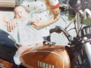 Baby Gayla sits on a motorcycle for the first time.